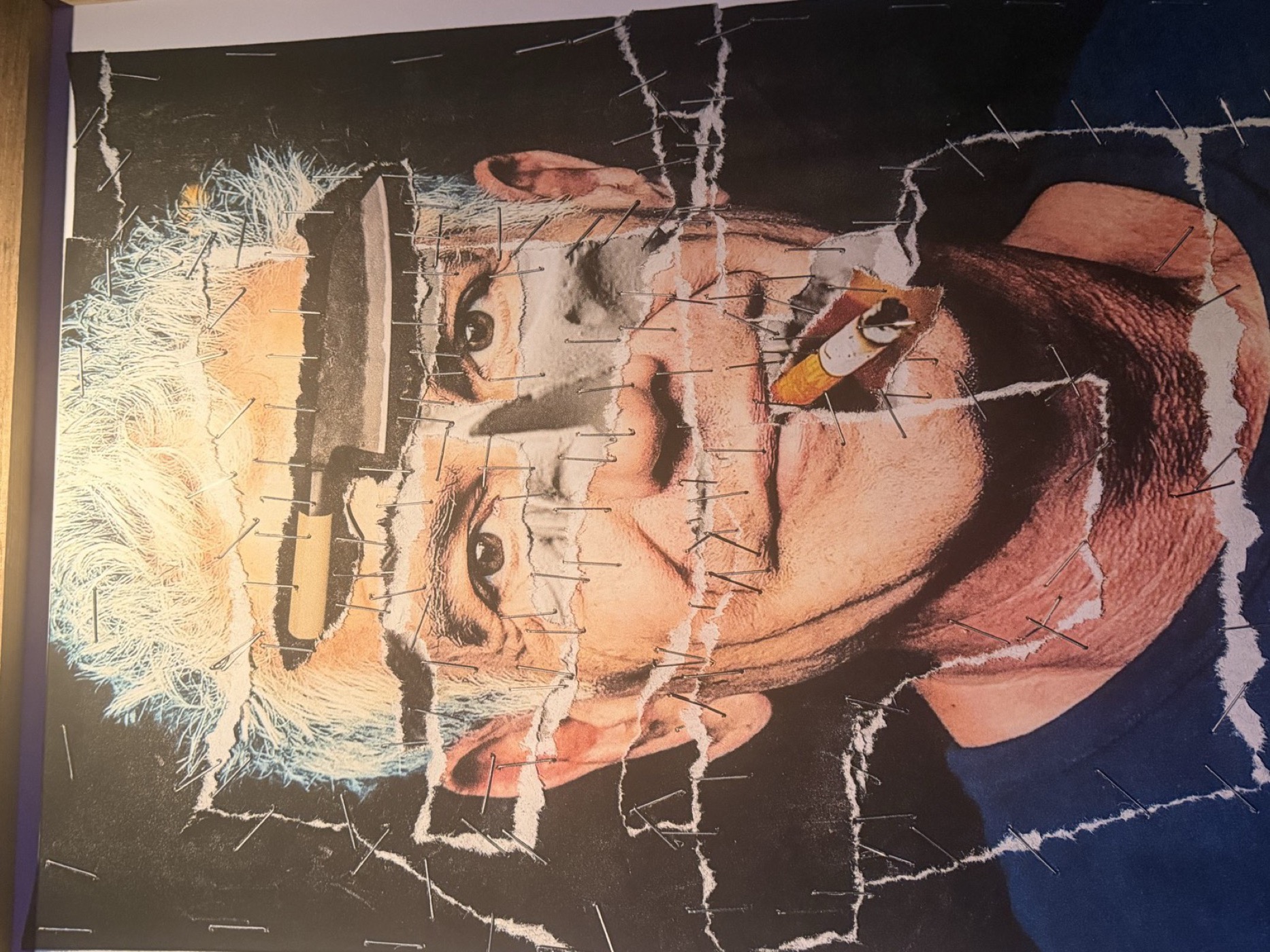 Stapled collage portrait with a kitchen knife torn through it