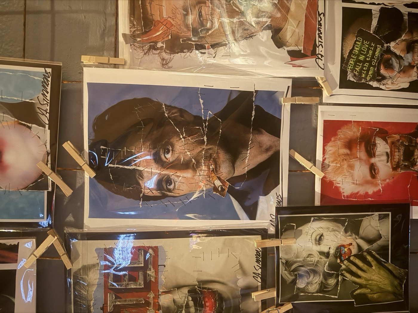Wall of stapled celebrity collages hung with clothespins