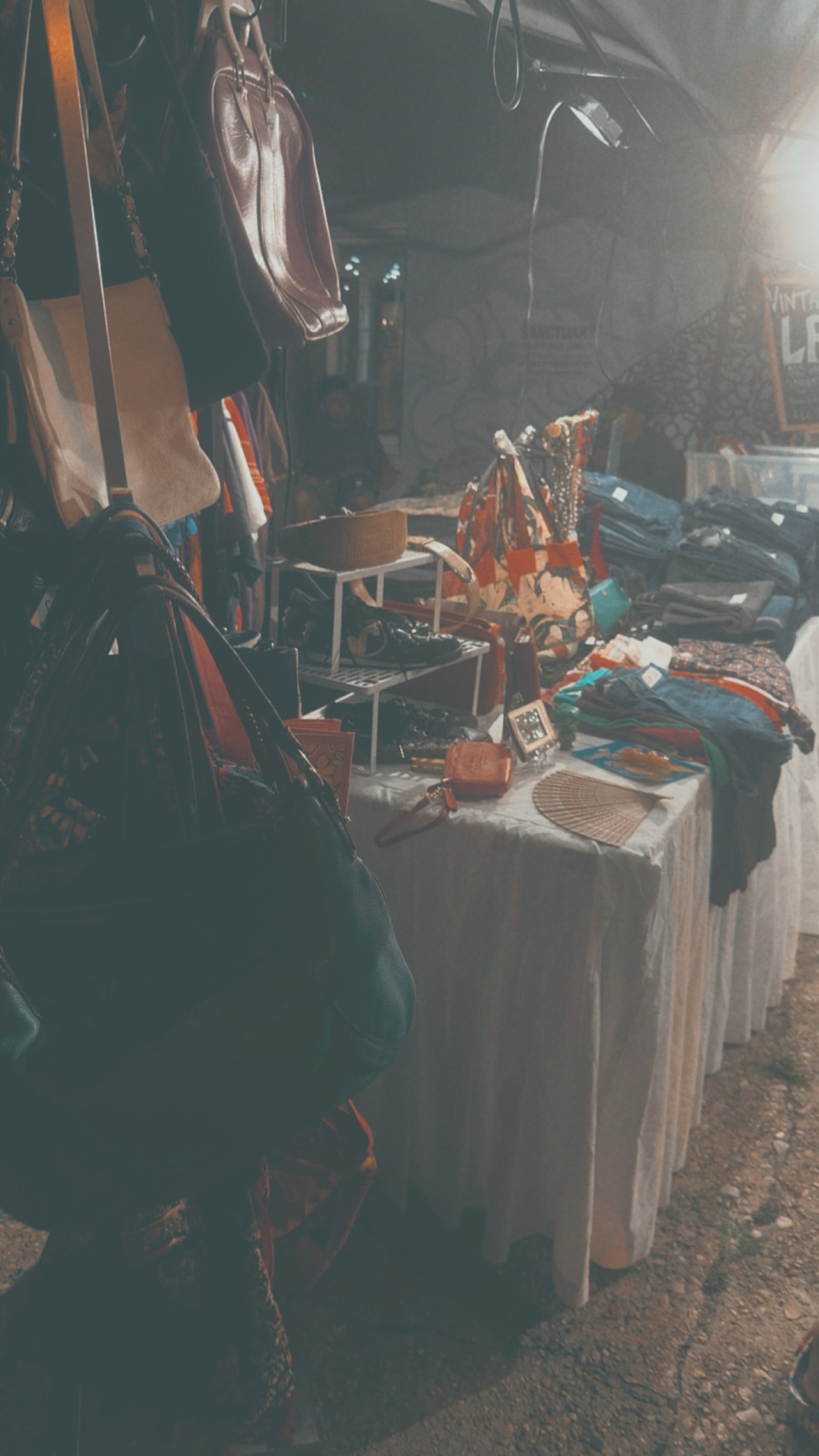 Vintage stall with bags and accessories under warm lights